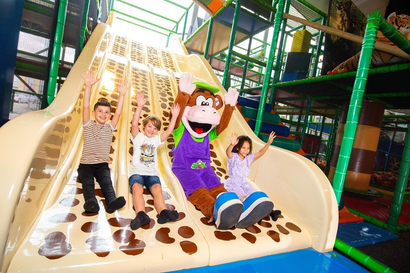 Kids and Monkeytown mascot going down a slide